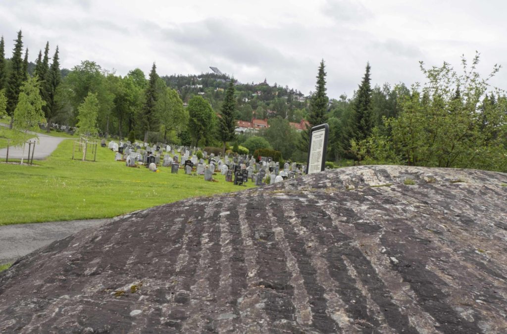 Voksen kirkegård meden stein som viser områdets geologiske historie 